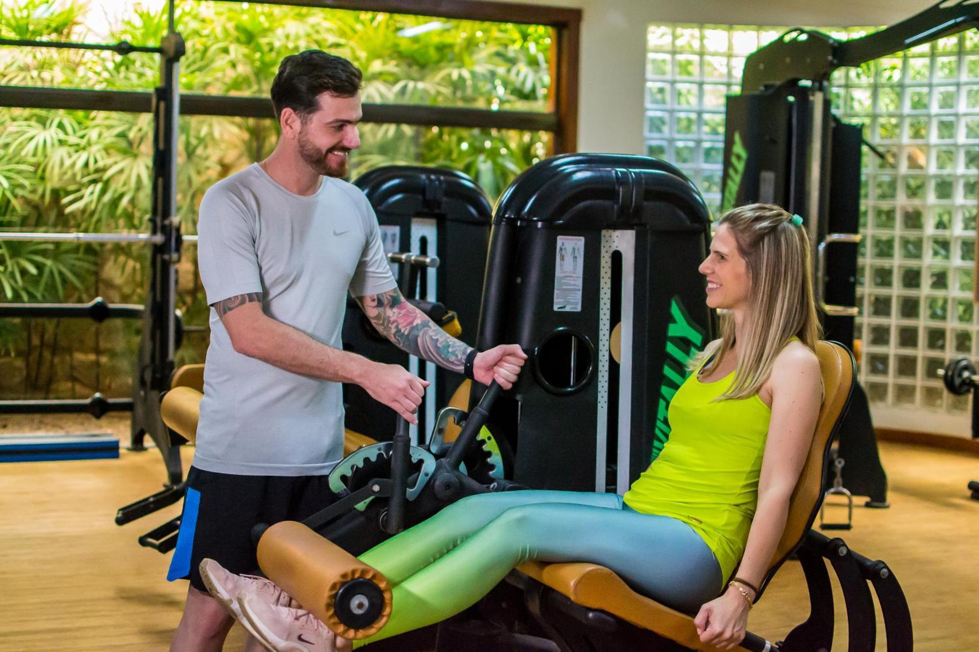 Blue Tree Thermas De Lins Resort Eksteriør billede Personal trainer assisting a woman on a leg press machine